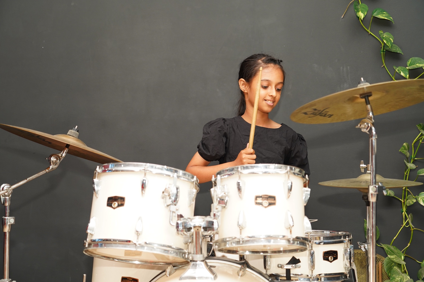 Young drummer performing on an acoustic drum kit at SARA Music School