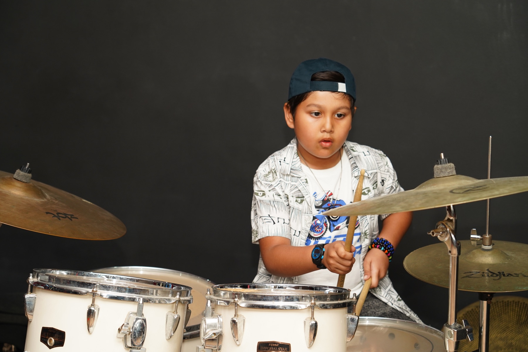 Young drum student developing rhythm and coordination at SARA Music School