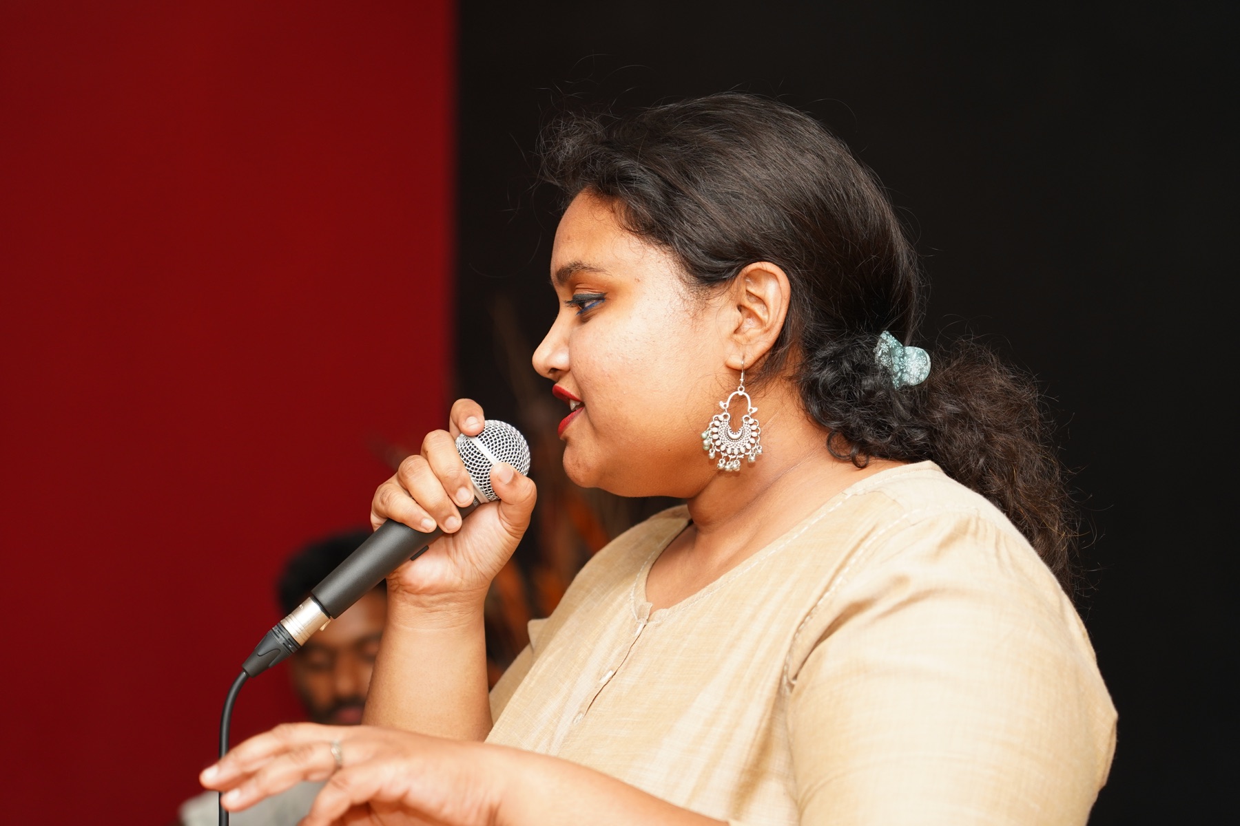 Western vocalist performing with a handheld microphone at a SARA Music School event